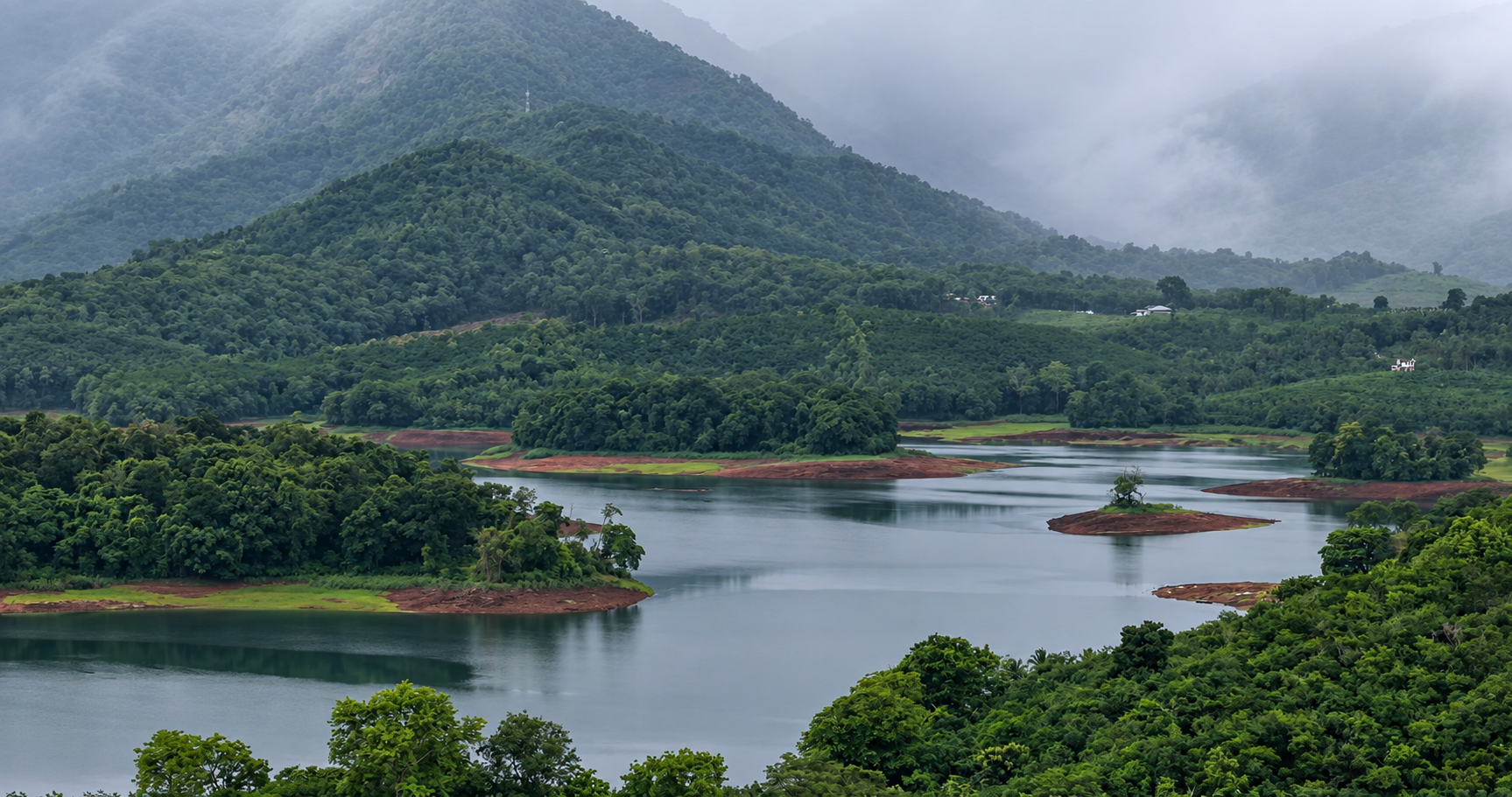 Mist drifting over the Kunjiyarpathy reservoir and densely forested mountains