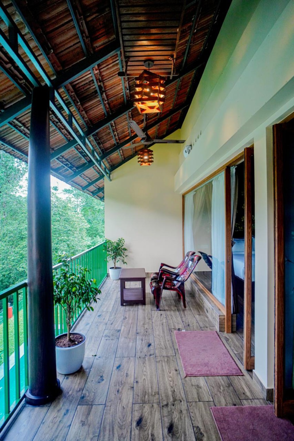 Timber balcony with bamboo ceiling, lantern lighting and seating overlooking the forest canopy