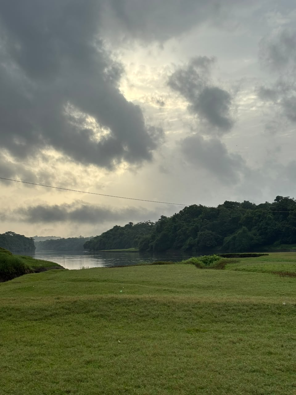 A quiet river running past green fields in the Western Ghats of Kerala