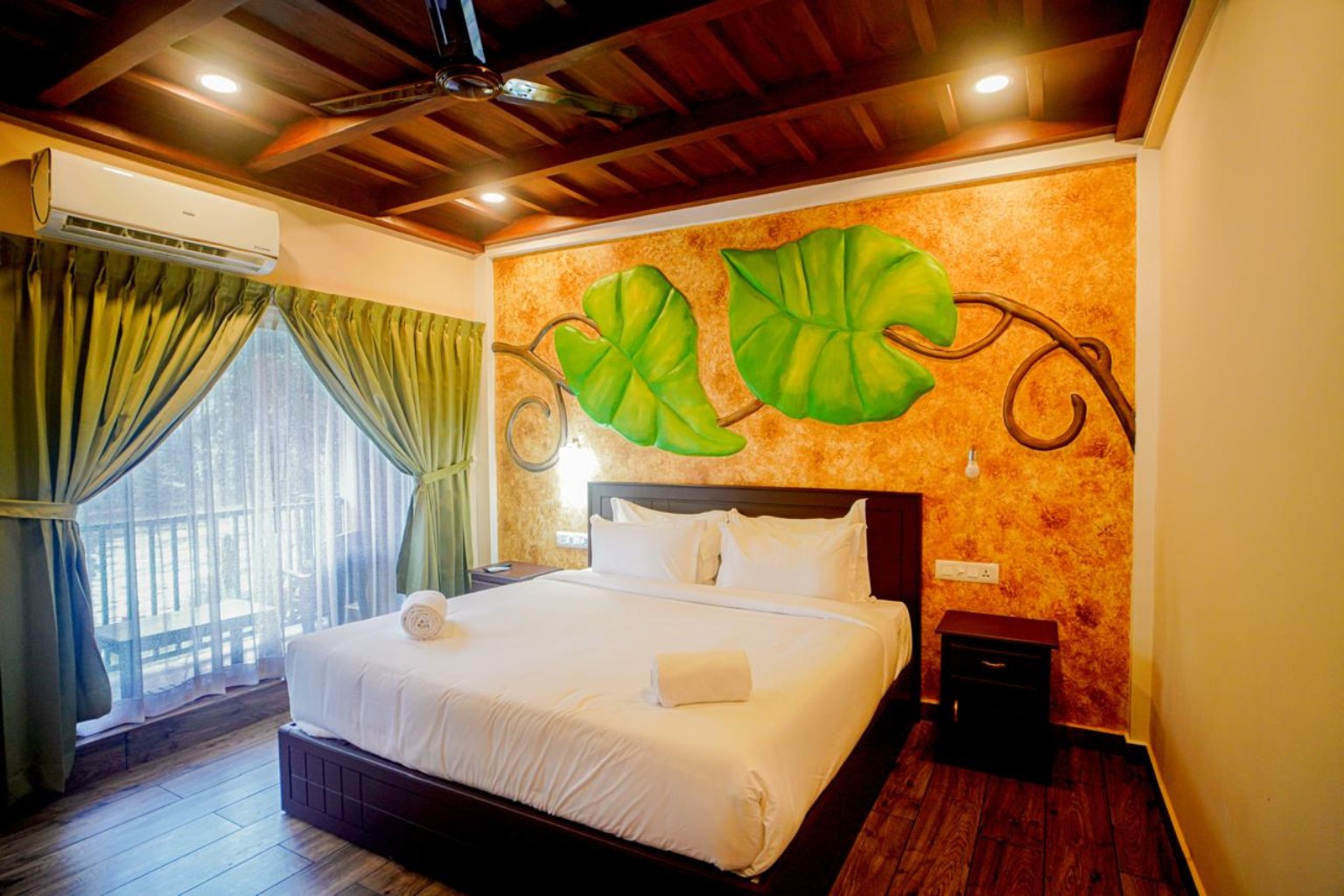 Warm-toned bedroom with sculpted green leaf feature wall, timber ceiling beams and a curtained balcony door