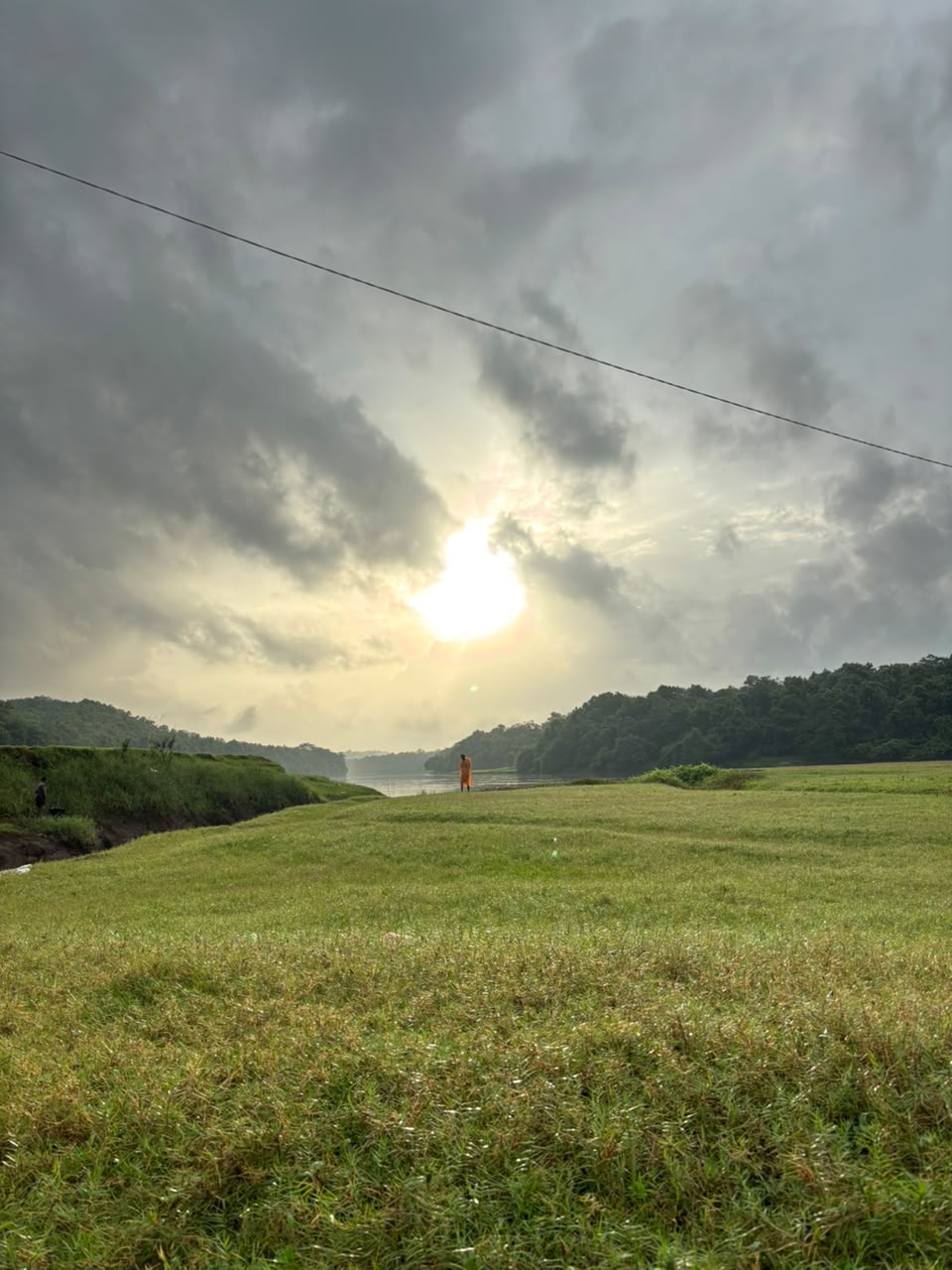 Sunset over the riverside green field near Pooyamkutty in Kerala