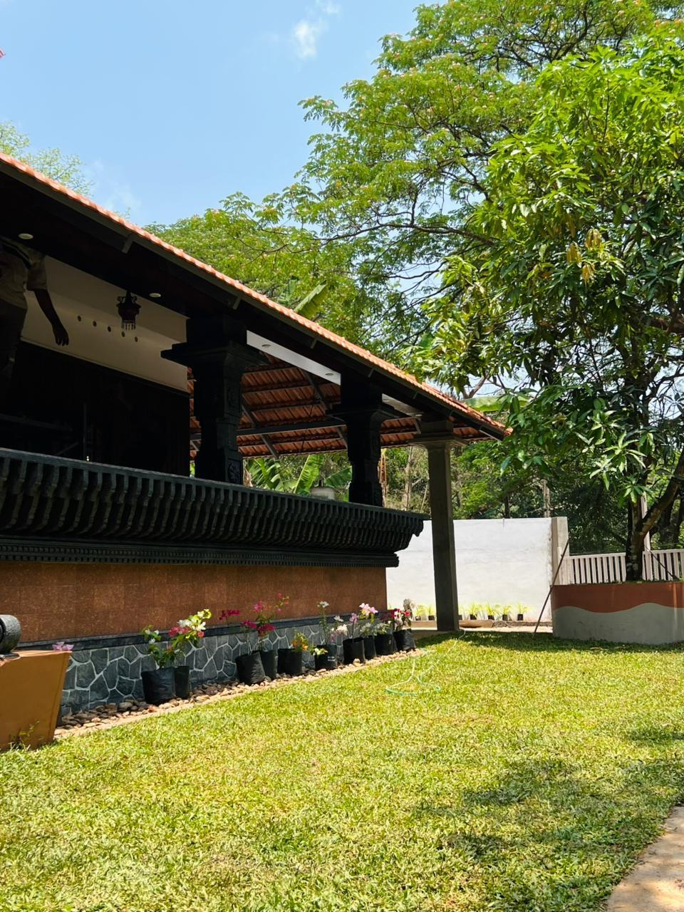 The house seen in daylight beneath its tiled roof
