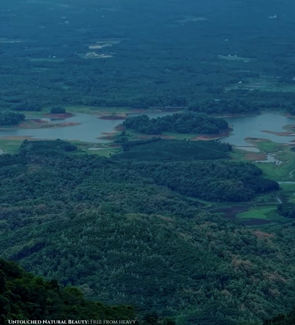 Mist-covered valley with a lake and forested hills at first light