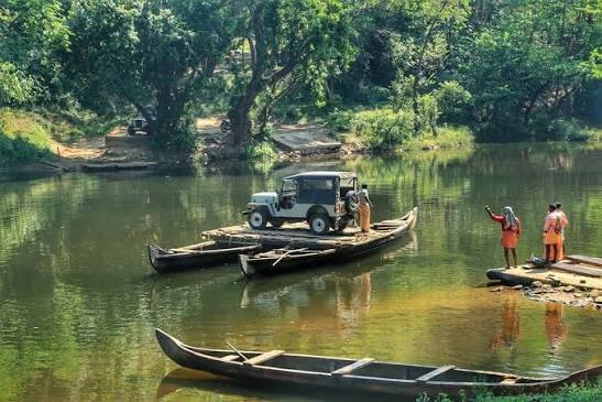 Local people crossing the Pooyamkutty river by small boat